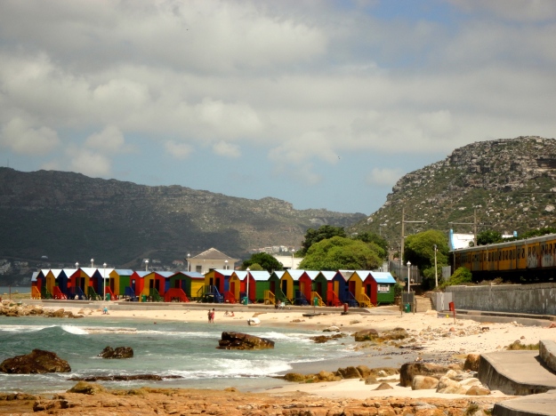 St.James beach change huts with the Metro train skirting the coastline all the way to Simons Town. 